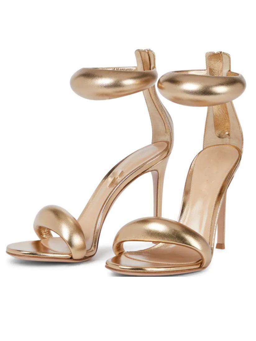Aleena Gold Ankle Strap Sandals, a stylish pair perfect for evening wear with a shimmery finish and comfortable heels.
