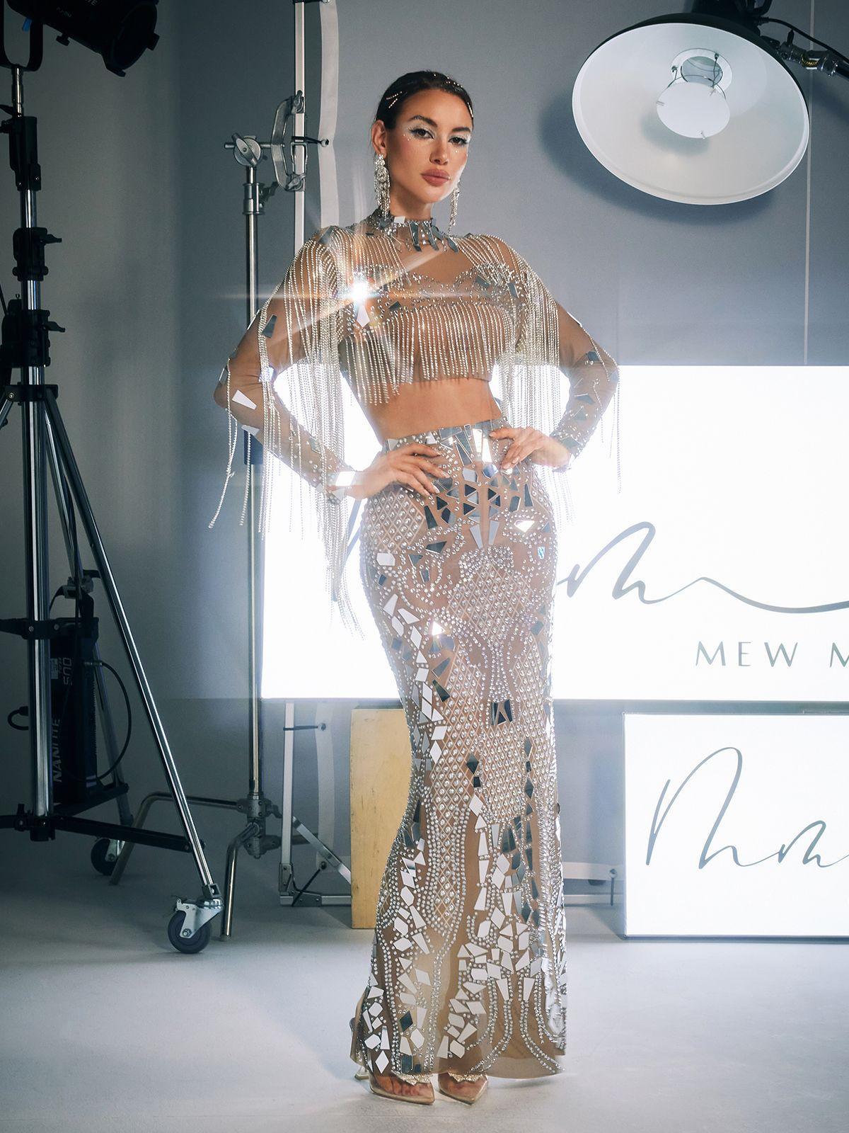 The Alvin Acrylic Fringe Skirt Set displayed on a hanger, showing the intricate rhinestone embellishments.
