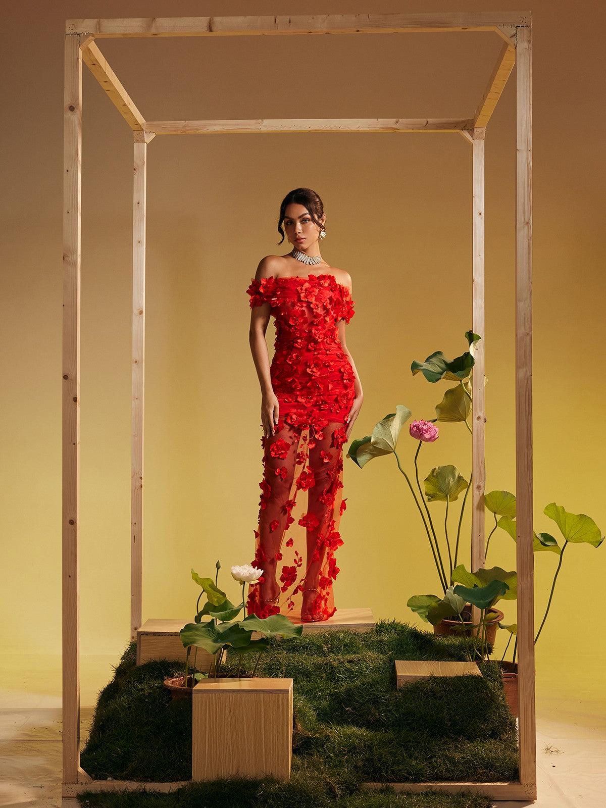 Model showcasing the Azizi Off Shoulder Flower Mesh Maxi Dress, capturing its beautiful flow and off-shoulder style at a cocktail event.