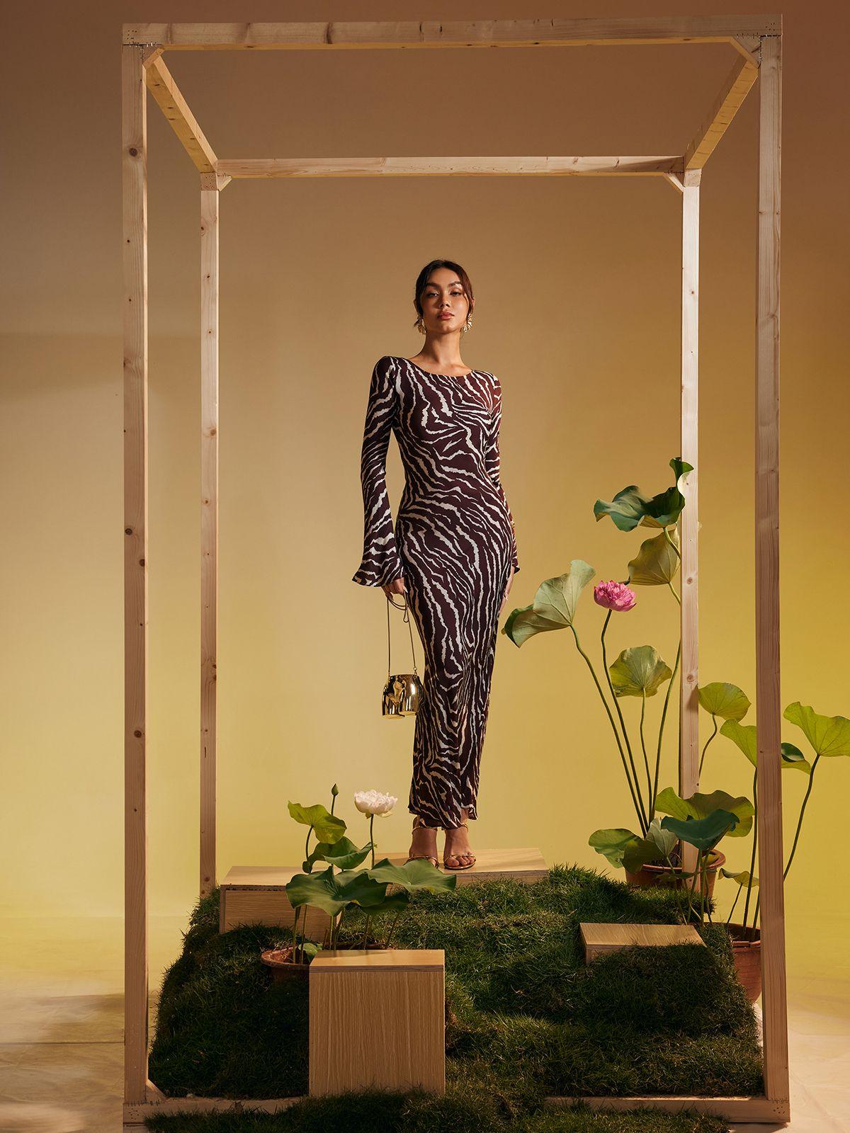 Model wearing the Cecily Long Sleeve Tiger Printed Maxi Dress at a beachside event.