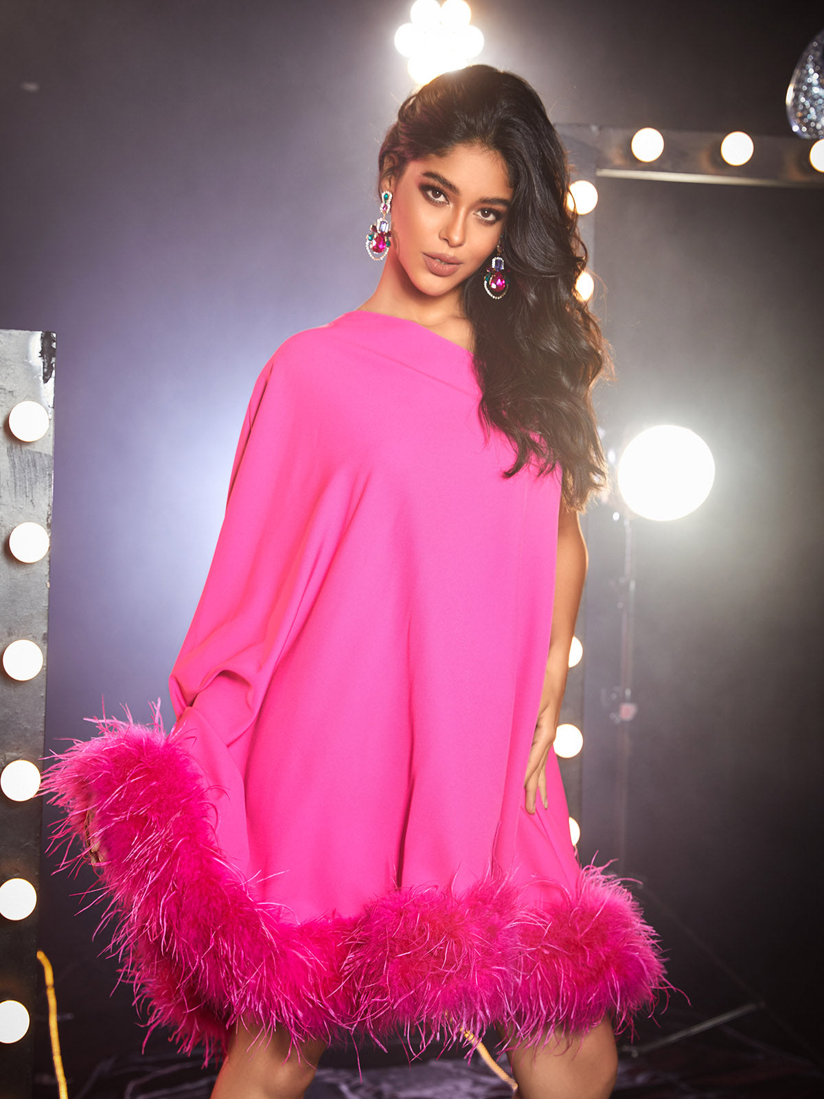 Back view of the Ceridwen One Shoulder Feather Mini Dress in hot pink, emphasizing its unique silhouette and flattering fit.