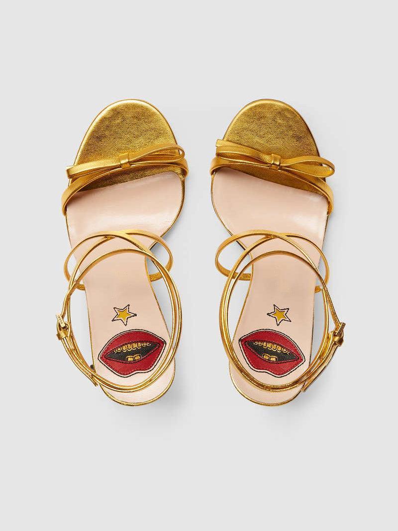 Juliette Metallic Snake Heel Sandals in Gold featuring a stylish ankle strap and unique snake motif.