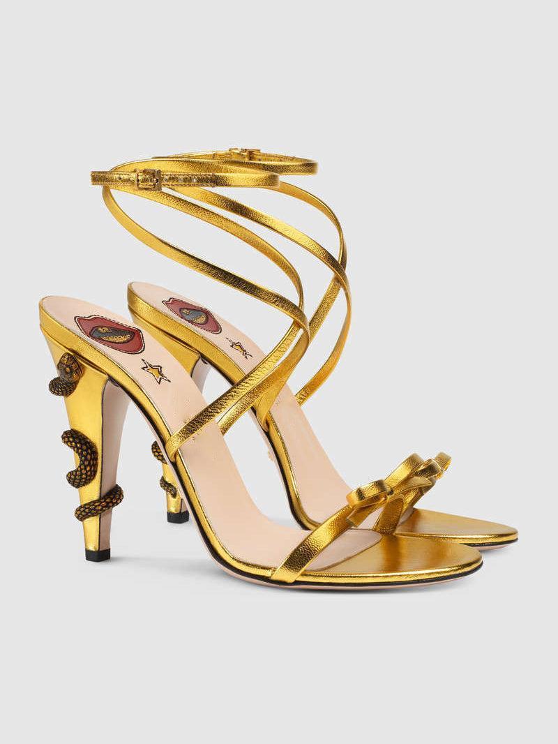 Juliette Metallic Snake Heel Sandals in Gold featuring a stylish ankle strap and unique snake motif.