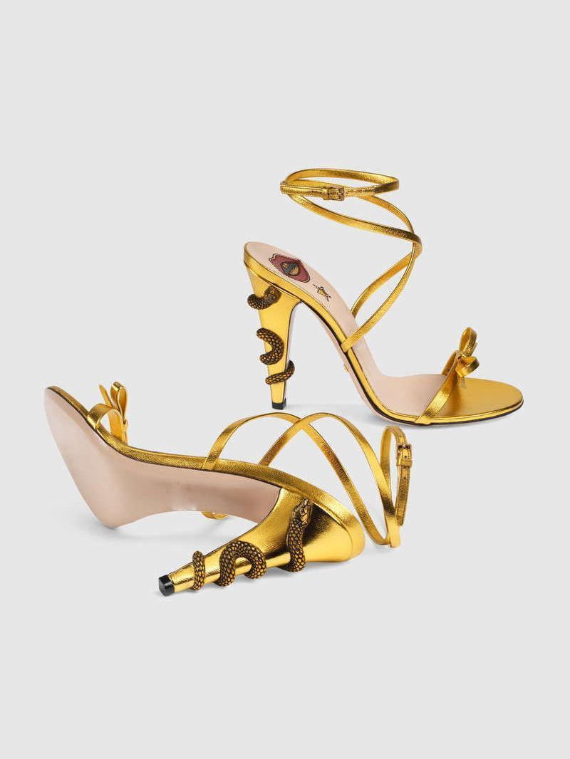 Juliette Metallic Snake Heel Sandals in Gold featuring a stylish ankle strap and unique snake motif.