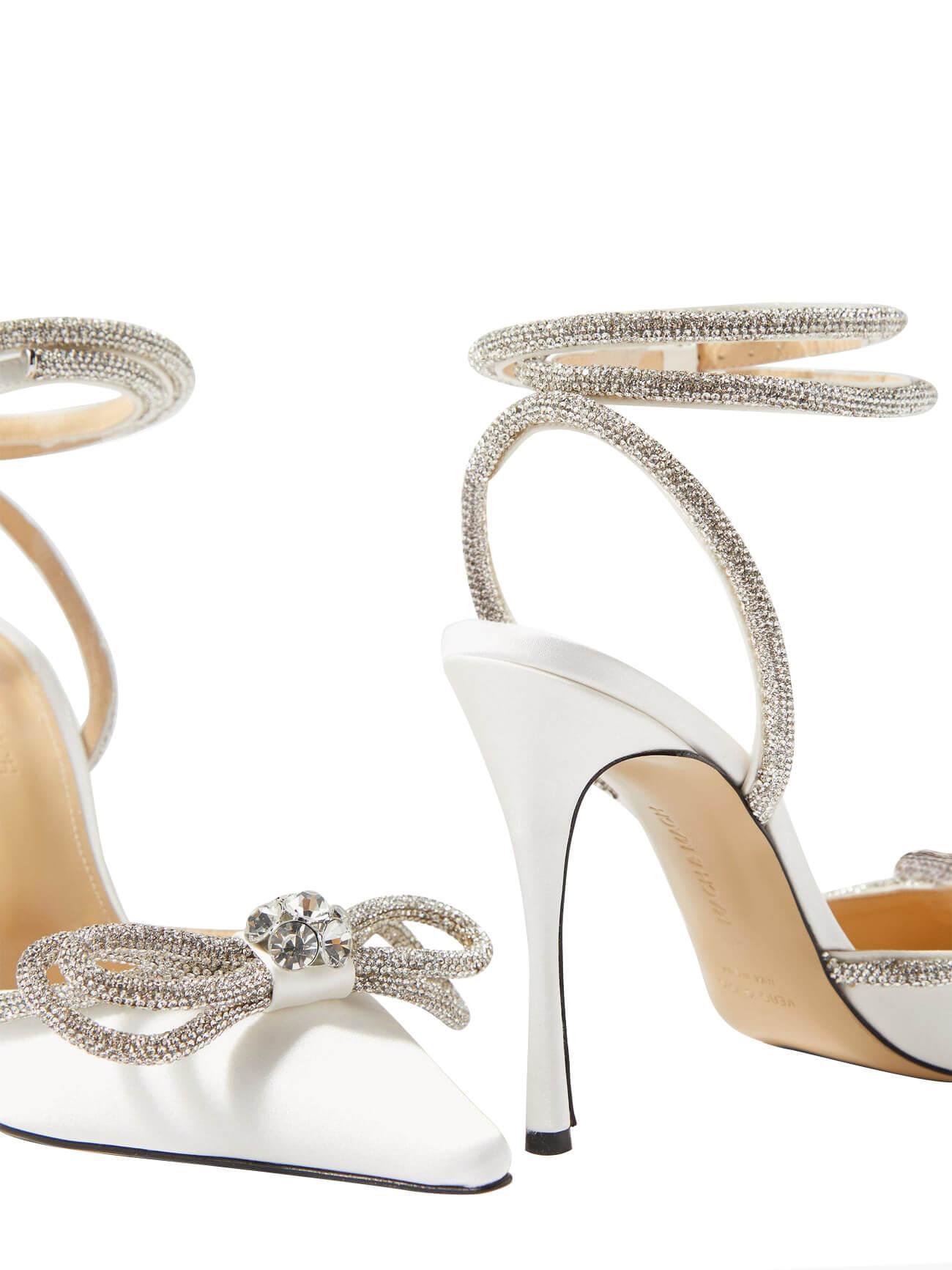 Elegant white satin high heels with a delicate crystal bow and ankle strap.  Pointed toe, 11cm heel. Custom-made luxury bridal shoes for special events.