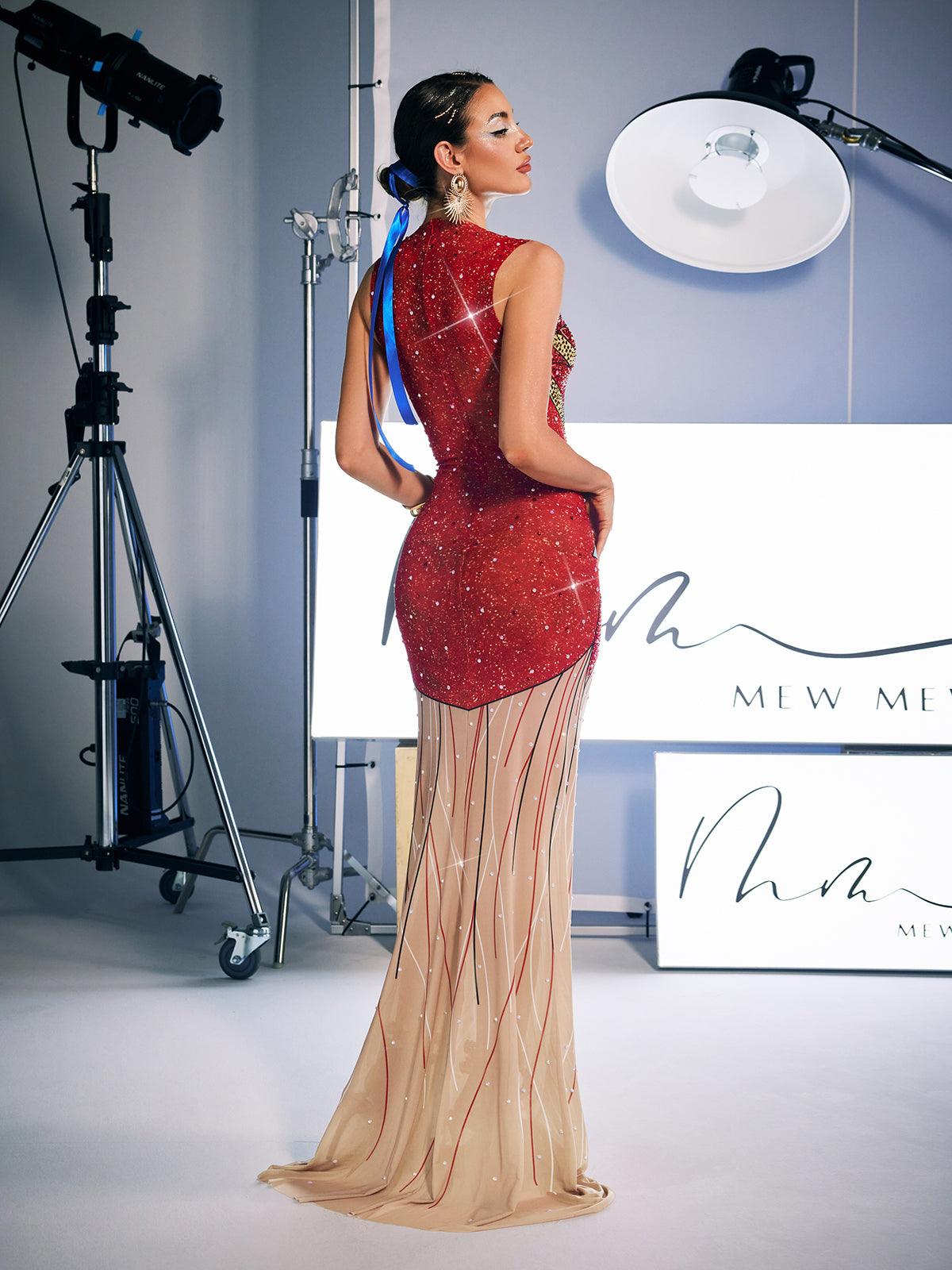 A stunning model wears the Leofric Crystal Pearl Embellished Maxi Dress, a luxurious red maxi dress adorned with crystals and pearls, perfect for special occasions.